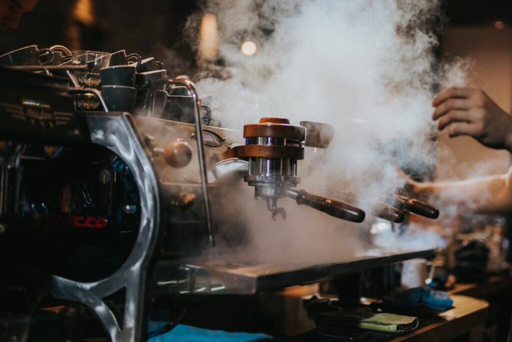 Steaming Espresso Machine in a restaurant. Photo by Krists Luhaers.