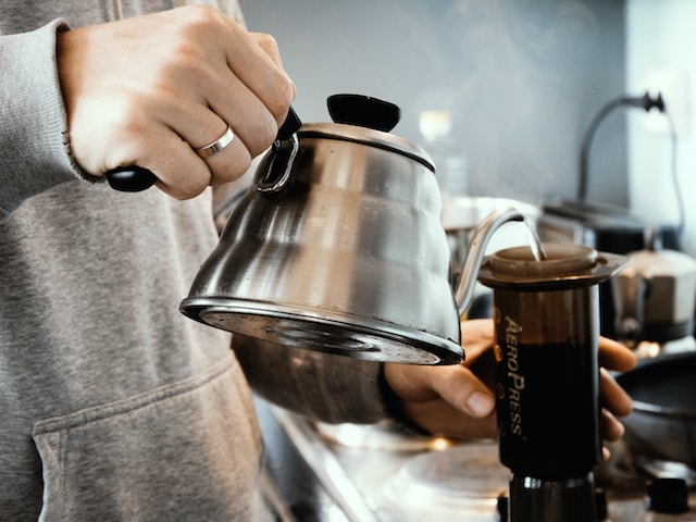 Person pouring coffee into AeroPress. Image by: Photo by Alex Chernenko.