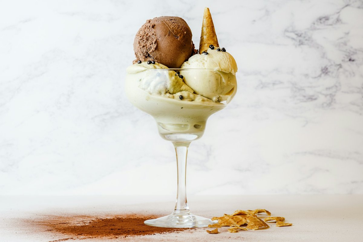 A hot espresso being poured over vanilla ice cream, the moment that defines an affogato.
