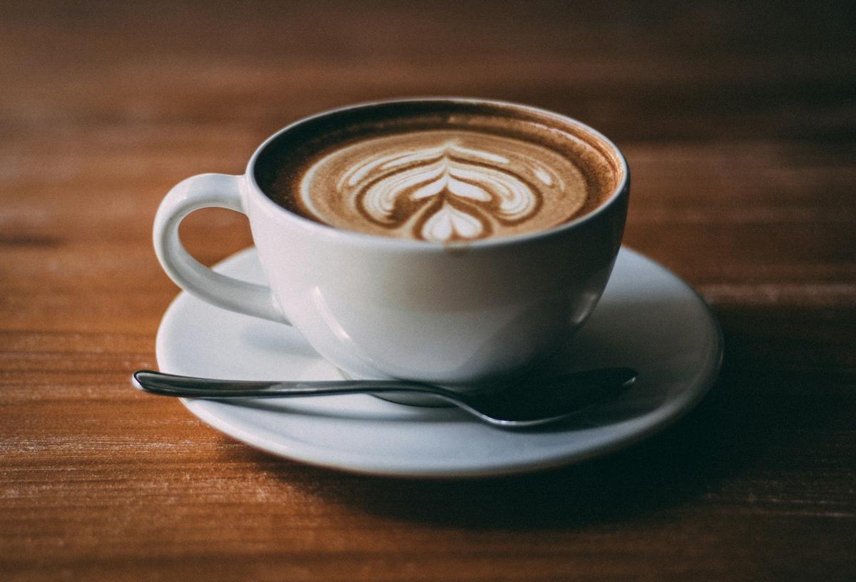 Close-up of a creamy milky coffee drink with thick microfoam, photographed by Jason W on Unsplash.