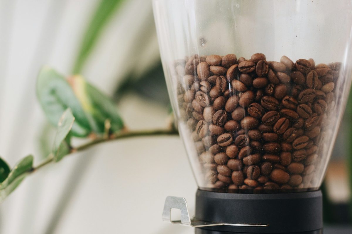 Coffee beans being ground in an electric burr grinder. Photo by Hümâ H. Yardım on Unsplash.
