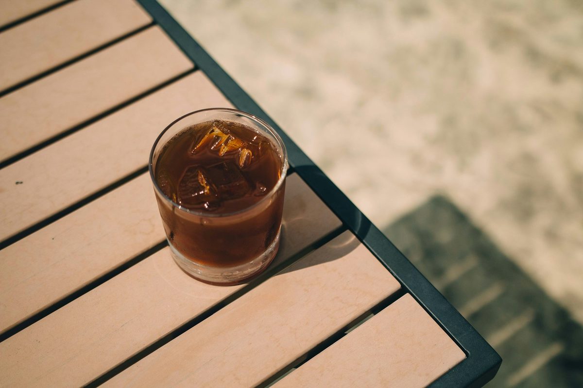 Cold brew coffee in a glass on a wooden table. Photo by Battlecreek Coffee Roasters on Unsplash.
