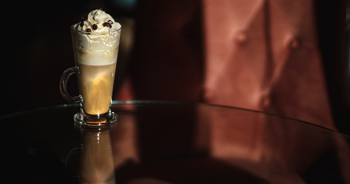 Irish coffee with cream floating on top in a glass mug